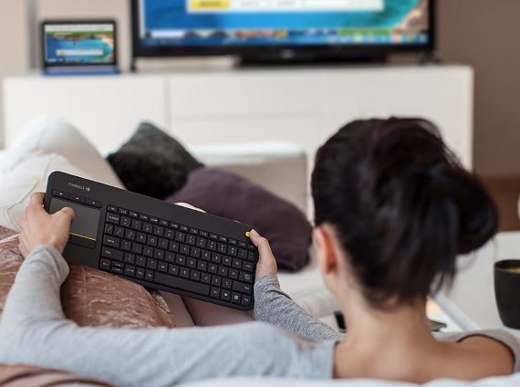 Kobieta z klawiaturą bezprzewodową podłączoną do telewizora